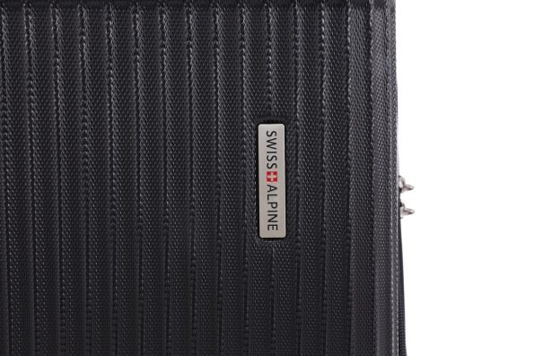 A textured black suitcase with a vertical silver logo plate reading "SWISS ALPINE."