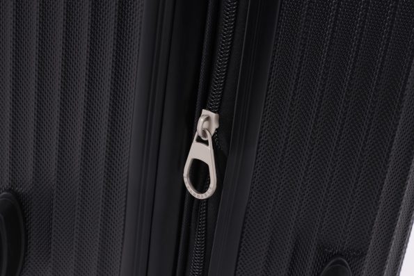 Close-up of a black suitcase's zipper with a silver pull tag labeled 'Expandable.'