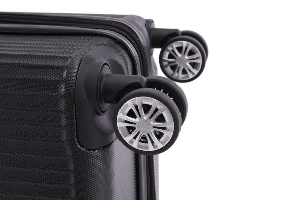 Close-up of a suitcase corner with two spinner wheels attached, featuring a textured black surface and silver wheel accents.